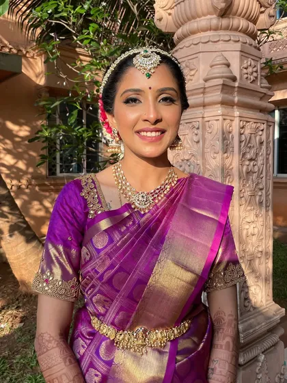 A beautiful Muhurtham look for a Tamil bride. Her smile is infectious, and the makeup is designed to be bright and radiant, with a highlighter that catches the light perfectly.