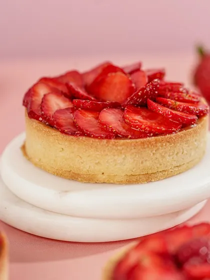 A close-up of our individual Strawberry Tart, highlighting the glossy finish on the strawberries and the crisp, golden-baked crust.