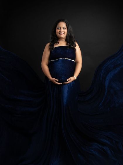 A powerful and symmetrical pose with the flowing blue gown creating a wing-like effect. This shot feels so strong and beautiful, celebrating the creative power of motherhood.