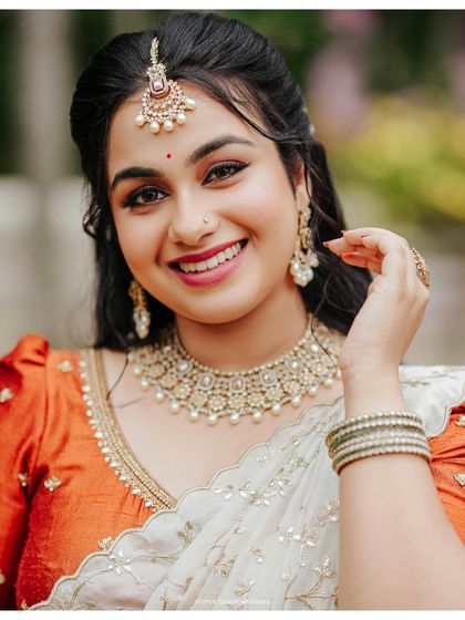 A stunning close-up portrait of the bride, her bright smile and elegant jewelry capturing her beauty and happiness on her engagement day.