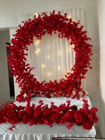 This striking design uses a bold red floral ring to create a powerful contrast against a softly lit white backdrop.
