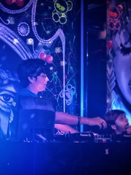 Setting the mood, one track at a time. This photo captures a moment of concentration at Toy Room, surrounded by the club's unique artwork.