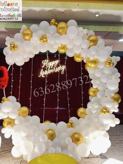 The circular balloon arch for the 25th anniversary, showing the combination of white and gold balloons with fairy light details.