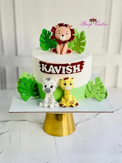 Welcome to the jungle. This adorable safari-themed cake features handcrafted lion, zebra, and giraffe figurines, perfect for a wild celebration.