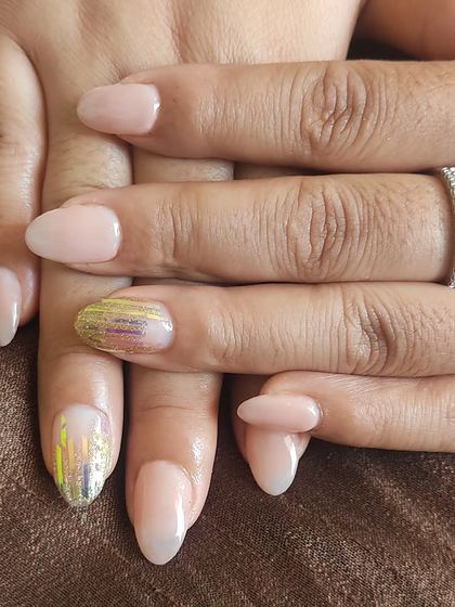 A simple nude manicure with two accent nails featuring a shattered glass effect using iridescent foils.