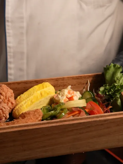 For corporate lunches or more intimate gatherings, I offer classic Japanese meal sets like this Noriben. It's a beloved bento box featuring layers of seasoned rice and nori seaweed, accompanied by traditional sides like karaage and tamagoyaki for a complete, comforting meal.