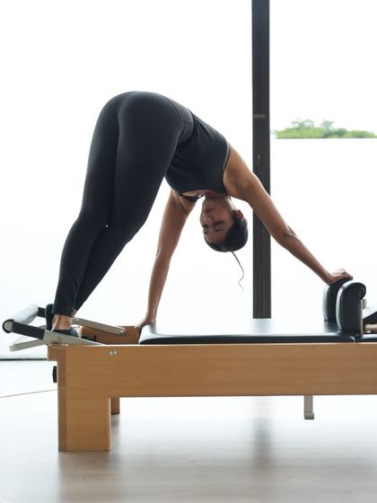 This 'downward stretch' on the Reformer is excellent for lengthening the spine and hamstrings. Precision and control are key to performing this movement correctly and safely.