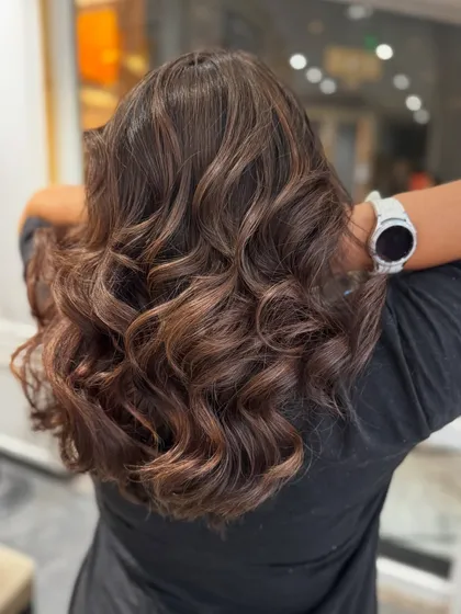 A mocha hair colour balayage with beautiful, soft curls that showcase the different brown tones.