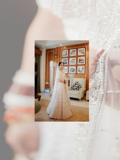 A beautiful bridal portrait, with the bride in her white lehenga framed by a soft, artistic overlay, creating a dreamy and elegant effect.