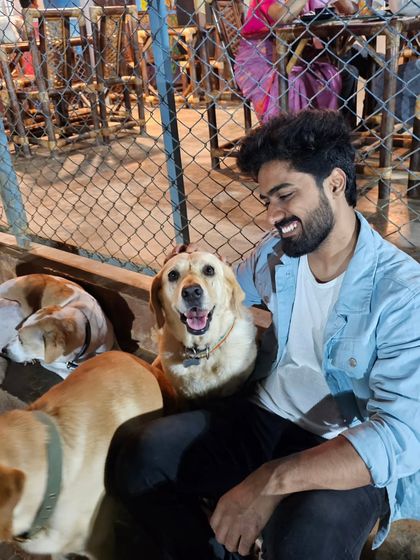 A visitor celebrating his birthday gets some love from a happy Labrador.