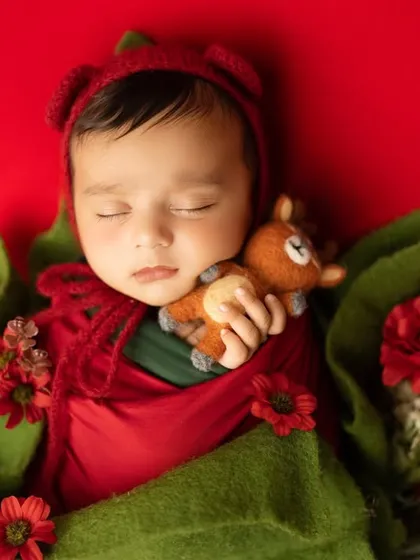 Adding a tiny, soft-toy reindeer brings a touch of whimsy to this Christmas-themed newborn photo. I carefully select props that are safe for your baby and add a storytelling element to the portrait.