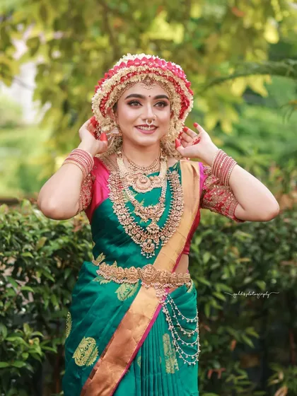 The bride adjusts her intricate floral headpiece, a candid moment that shows the scale and beauty of this traditional adornment.