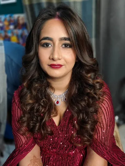A close-up of this gorgeous reception glam. The look features a soft brown smokey eye, a deep berry-red lip, and beautiful, bouncy curls that frame the face perfectly.