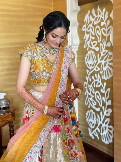 A lovely posed shot of the bride, looking down at the details of her vibrant lehenga.