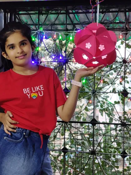 A student proudly holding the beautiful paper lantern she made for Diwali. Our festive workshops are a great way to get into the holiday spirit.