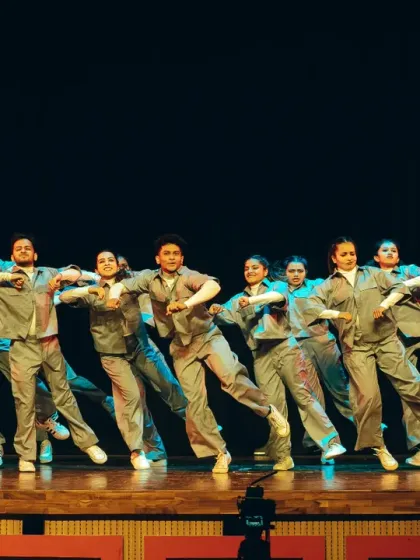 A synchronized group performance in matching grey outfits, showing the precision and unity of the batch.