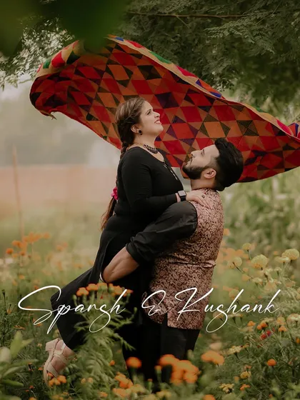 A vibrant and playful moment from a Punjabi-themed pre-wedding shoot. The colorful phulkari dupatta adds a beautiful cultural element to this fun and romantic lift.