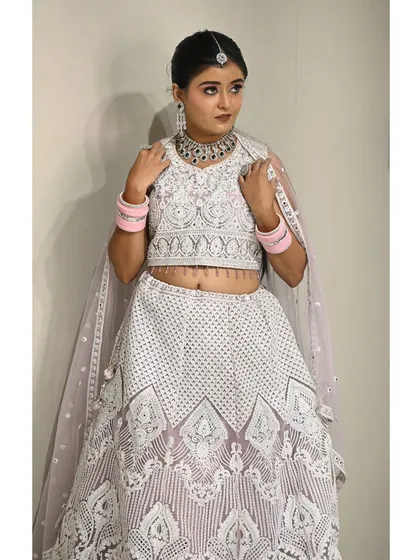 A complete look featuring the white rental lehenga. The sleeveless blouse and lightweight skirt make it comfortable to wear for long hours.