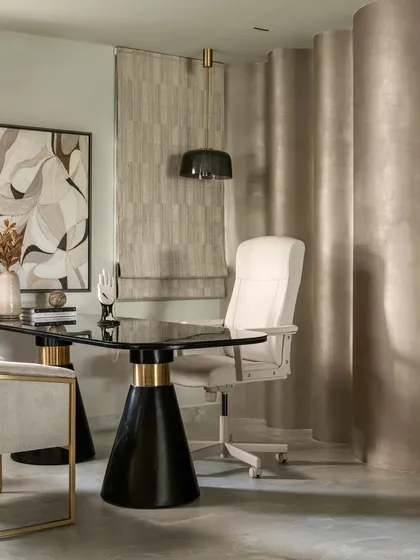 This corner of our studio is designed as a model home office. It features a bespoke desk with bold black and gold conical legs and a comfortable, stylish office chair, proving that a workspace can be both highly functional and exceptionally elegant.