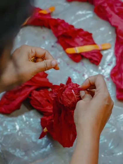 Tying the fabric with string is a key part of the Shibori tie-dye technique. These resists prevent the dye from reaching certain parts of the fabric, which is how the beautiful white patterns are formed.