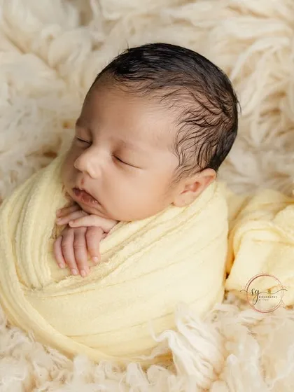 A classic "potato sack" pose, where the baby is safely and comfortably wrapped to look like a sweet, snug bundle.