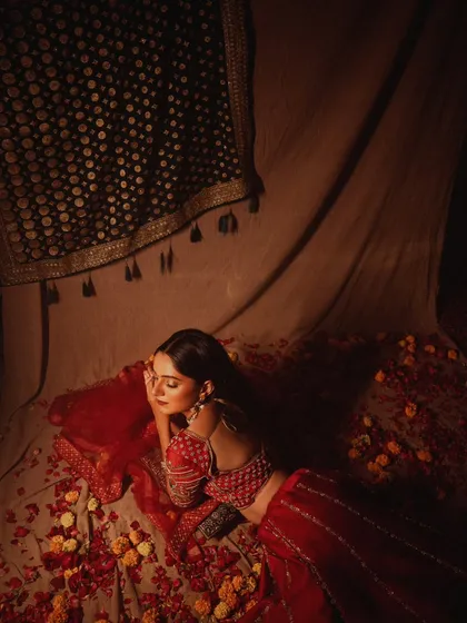 An overhead shot of the bride resting on a bed of petals. This artistic composition creates a beautiful, painterly image full of romance and texture.