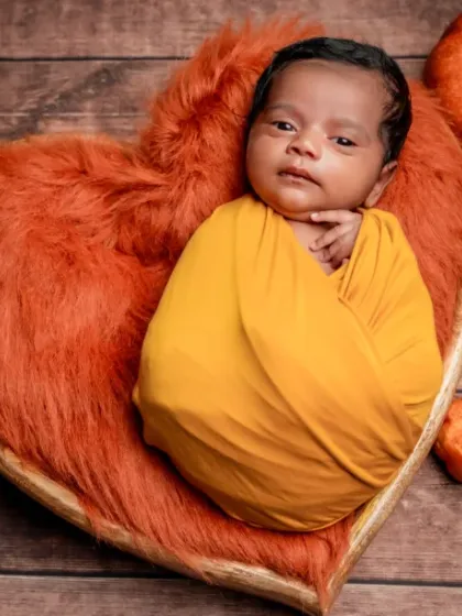 Snug as a bug. This baby is wide awake and taking in the sights, nestled in a heart of orange fluff.