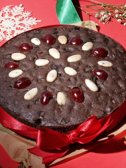 A festive Christmas plum cake decorated with cherries and almonds, surrounded by holiday props. This demonstrates my ability to create themed and seasonal food photography for special campaigns.