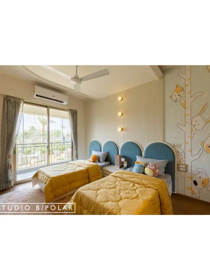 For this shared kids' room, we used a unisex palette of blue and yellow to create an energetic yet balanced space. The arched blue headboards and whimsical wallpaper create a fun and inviting atmosphere.
