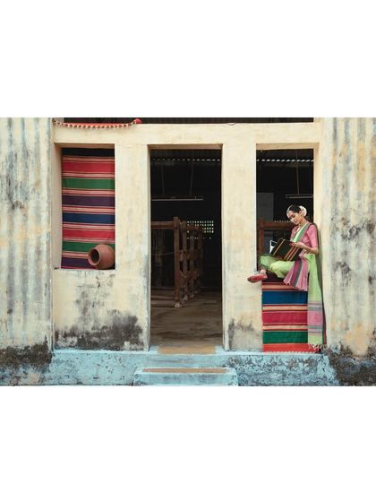 A quiet moment during the Jamakalam shoot, seated in the doorway of a weaver's workshop. The setting itself tells a story of heritage and craft.