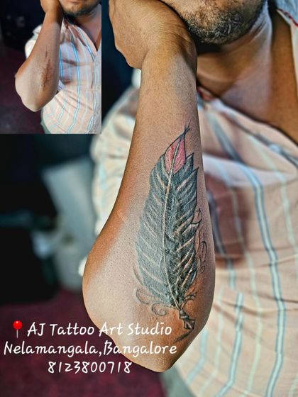 A scar and old ink on the elbow are now hidden beneath this detailed feather tattoo.