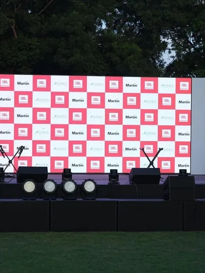 This is a frontal view of the stage setup for the Harman professional demo event. It shows the clean and organized placement of stage monitors for the performers, microphone stands, and the main front-of-house speaker stacks, all positioned for maximum audio impact.