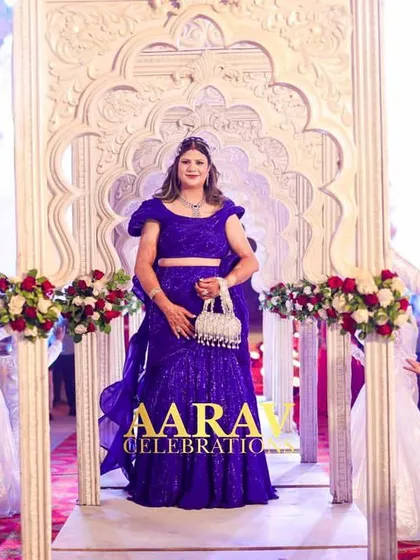A grand entry for the bride at a 25th-anniversary celebration at Chomu Palace. She stands on a magnificent white float, welcomed by cheering dancers, making her feel like a star.