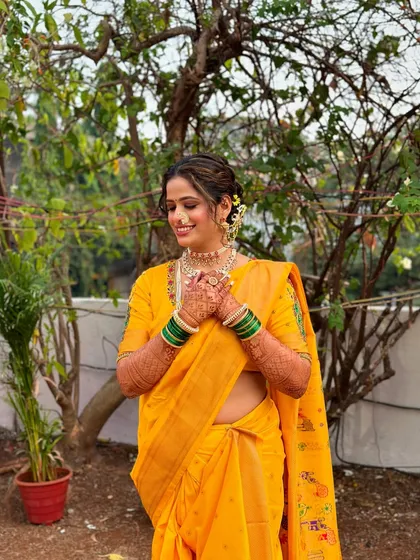 A happy bride in her yellow Navari. The makeup is kept fresh and dewy to match the bright, daytime ceremony vibe.