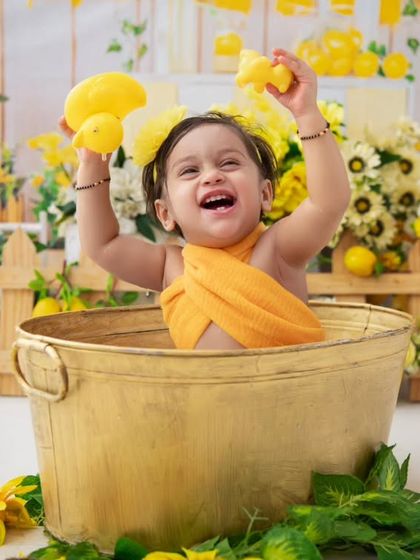 Pure joy! This baby is having the time of her life playing with the rubber ducks in her sunny, lemon-themed milk bath.