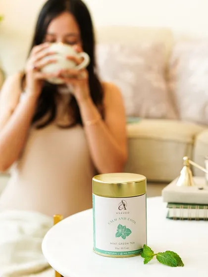 A cozy evening scene with a woman enjoying a cup of mint green tea. This shot evokes a sense of calm, relaxation, and self-care.