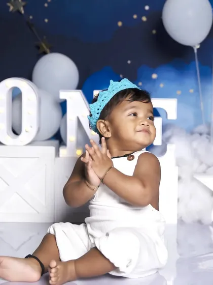 Clapping with excitement for turning one! This candid shot captures the pure happiness of a first birthday celebration.