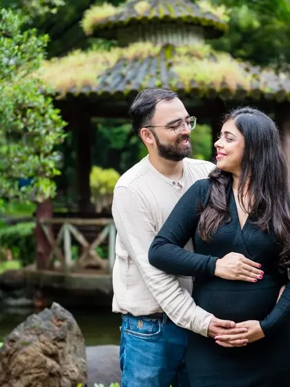 A classic couple's pose in a beautiful garden setting, with a Japanese-style gazebo in the background. Their love for each other is clear to see.