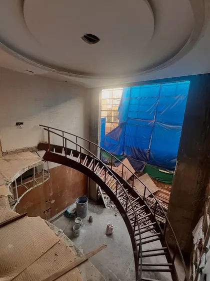 An overhead view of a site under construction, showing the framework for a dramatic curved staircase. Regular site visits are essential to oversee complex structural elements and ensure quality control from the ground up.