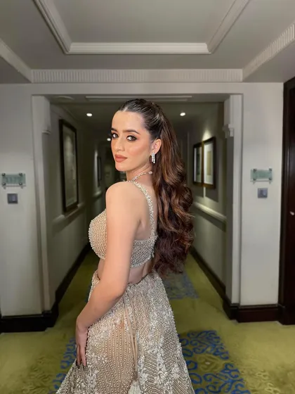 This glamorous half-up, half-down hairstyle is one of my favorites for a reception or sangeet. I created voluminous, cascading curls and a sleek, high-crown pony to give the bride a look that is both royal and ready for the dance floor.