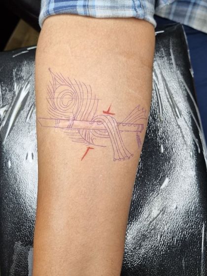 The custom stencil for the flute tattoo is placed directly over the scar, showing how the design is planned to incorporate and hide the mark.