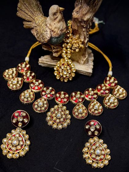 The magic of Polki Kundan jewelry in a single frame. This red set, featuring a choker, earrings, and maang tikka, is a blend of heritage and modern bridal style.