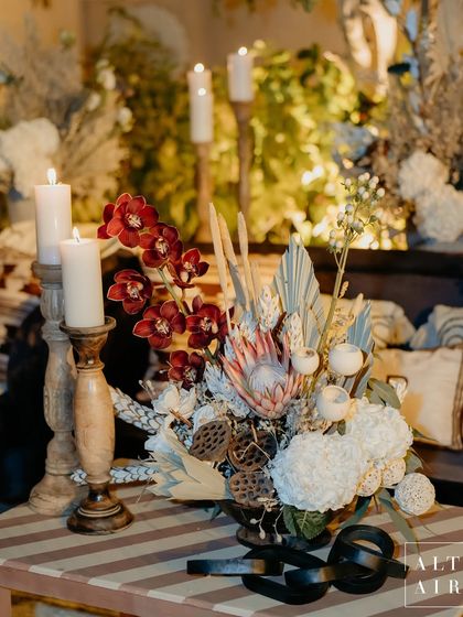 A beautiful floral arrangement from the 'Muted Melodies' sangeet, featuring dried elements, protea, and orchids. The earthy, contemporary aesthetic was a step away from traditional concepts.