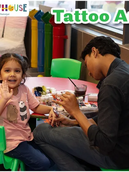 A happy little girl waves as she gets a temporary tattoo. This is one of our most popular party activities, with lots of fun designs to choose from.