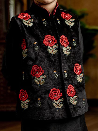A close-up of the bold red rose embroidery on our black velvet Bundi. The texture of the velvet combined with the vibrant threadwork creates a truly stunning effect.