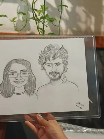 A close-up of a couple's caricature, showing the detail of the hand-drawn pencil sketch.