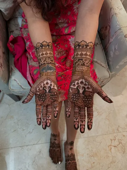 A majestic peacock design takes center stage on the palms, a timeless symbol in Indian mehndi art, surrounded by intricate supporting patterns.