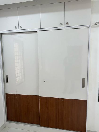 A modern sliding wardrobe with a two-tone design of white and wood. Sliding doors are an excellent choice for bedrooms where space is a constraint.