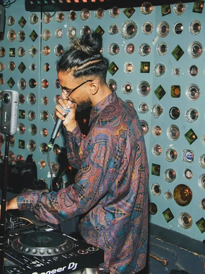On the mic and in the mix. This shot captures me engaging with the crowd while lining up the next track. It's a constant flow of energy.