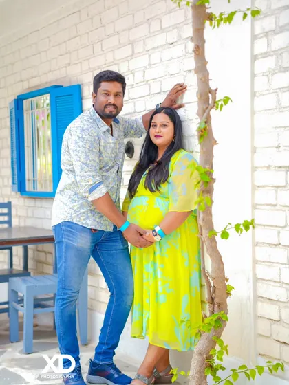 A happy couple's portrait against a white brick wall, capturing a moment of genuine connection.